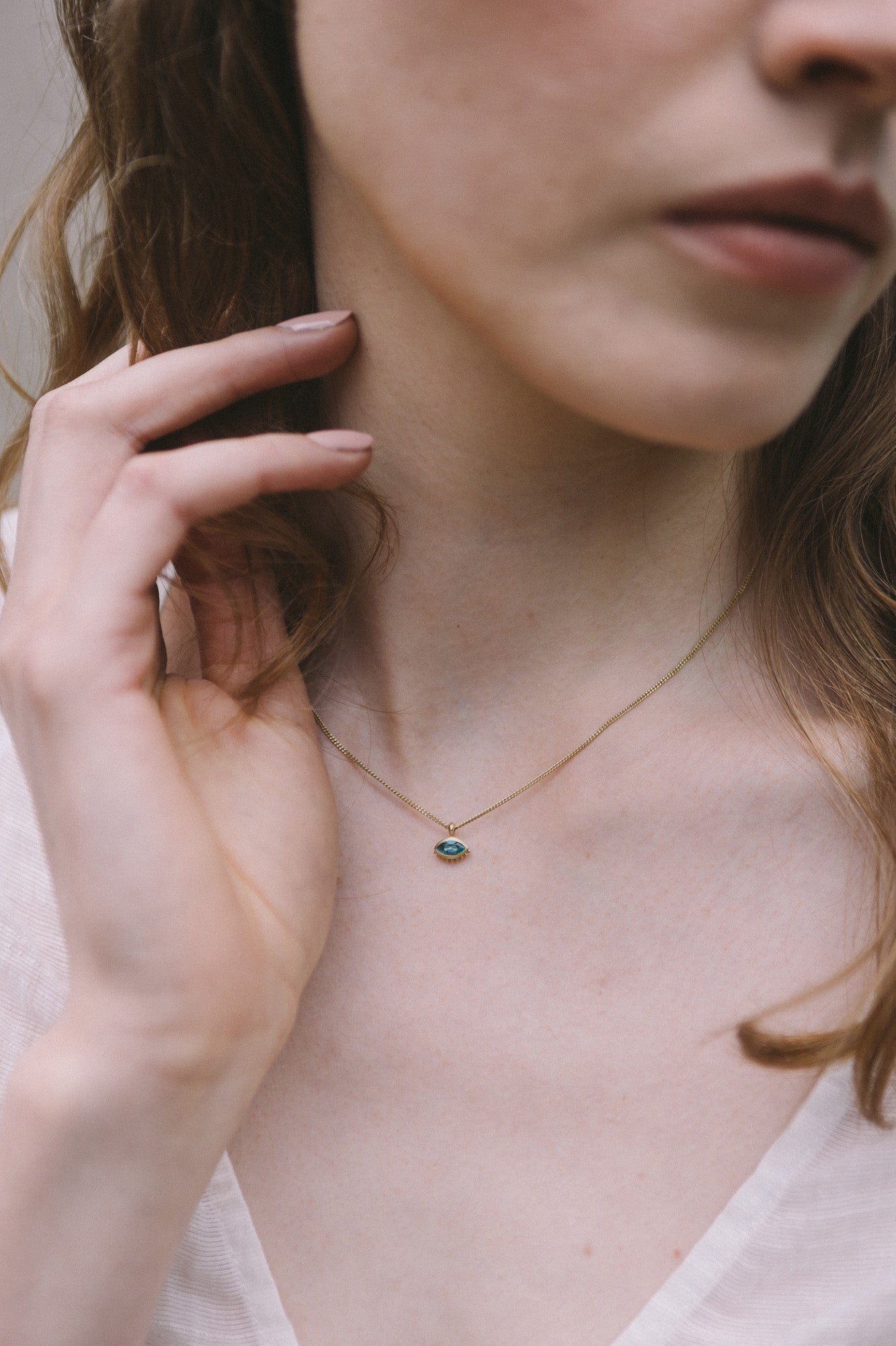 Woman modelling the Cheshm Gold Pendant by Moznabi Jewellery