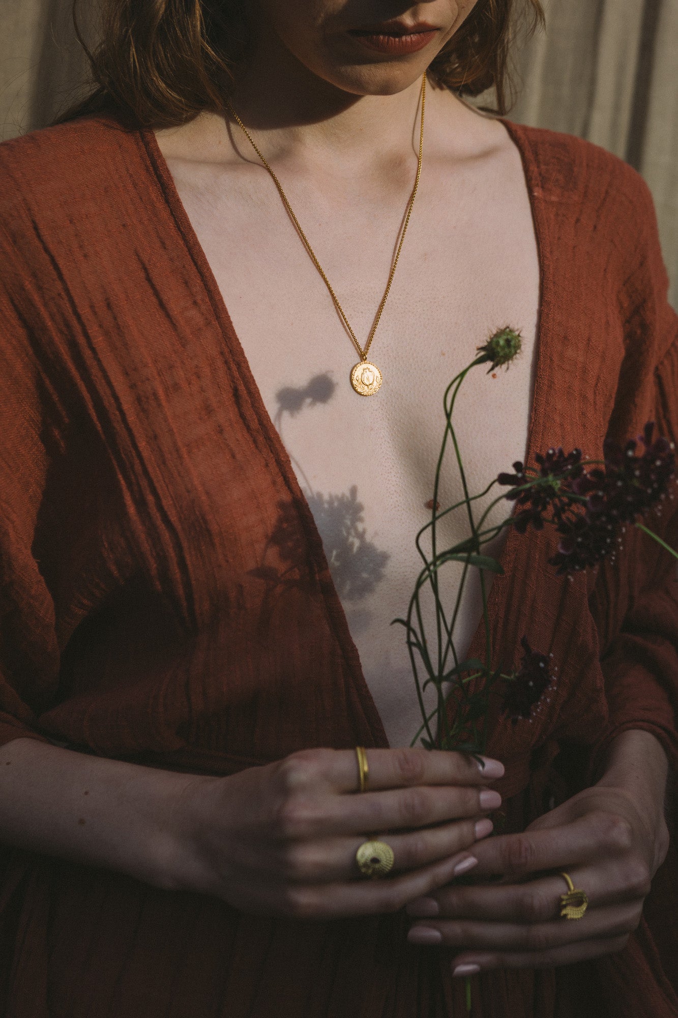Woman wearing the Anar Gold Pendant handmade by Roxanna Moznabi